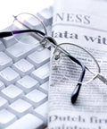 Complete Eyeglass Repair Kit Featuring 1500 Micro Screws And Nose Pads For Glasses Sunglasses And Prescription Frames on a desk with newspaper and keyboard.