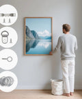 Person using Pro Level Picture Hanging Wire Kit With D Rings And Wall Mount Screws For Frames And Canvases to hang wall art.
