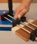 Close-up of a small stock holder for router tables securing tiny wood pieces, designed for safe feeding and precise freehand cuts.