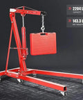 Heavy Duty Hydraulic Engine Hoist And Foldable Shop Crane With Rollin Wheels One Ton Lifting Capacity And Four Adjustable Boom Positions For Tackling Engine Swaps In Your Garage Workspace lifting a red toolbox.