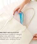 Everyday Mini First Aid Kit For Women And Moms with 27 essentials, visible in a shiny clutch inside a white handbag, ideal for travel.