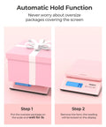 Killer Digital Postal Scale Measures Every Package Up To 66 Pounds With Dead On Precision So You Can Ship Heavy Goods Without Stress While The Sleek Pink Surface Looks Absolutely Dope showing automatic hold function with a pink package.