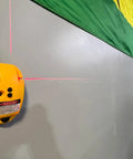 90 Degree Laser Level Tool With Red Beam For Interior Walls, Super Handy For Home DIY Projects, Delivers Straight Line And Cross Line Plus Vertical Corner Line, Self Leveling Laser Gauge For Picture Hanging Cabinets And Tight Layouts mounted on gray wall