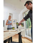 Professional Grade Brushless Percussion Drill With Killer Torque And All Metal Chuck 18 Volt Cordless Power Tool in use on wooden surface.