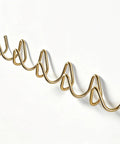 Heavy Duty Gold Wall Mounted Coat Rack With Sculpted Wavy Hooks, showcasing five hooks ideal for hanging coats and bags.