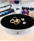 Premium Rotating Jewelry Display Stand With Smooth Electric Turntable Spin For Selling Accessories And Cosmetics with rings on black velvet.