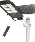 Heavy Duty Solar Security Flood Lights With Hella Bright Motion Sensor And Rock Solid Dusk To Dawn Operation IP66 Weatherproof Wall Mount For Backyards Driveways And Commercial Sites, shown mounted with remote control.