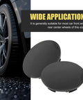 4 Pack Universal Car Wheel Center Caps Sixty Millimeter Outer Diameter Fifty Six Millimeter Inner Bore Tough As Nails ABS Plastic Snap On Rim Hub Caps view with black caps next to car wheel.