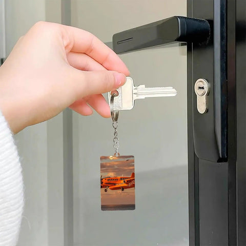 Hand holding key with Orange Daylight Aircraft Keychain Set With Personalized Acrylic Keyrings, Chains And Jump Rings at door