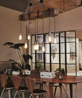 Rustic Industrial 8-Light Pendant Chandelier For Dining Room And Kitchen Island illuminating a cozy, vintage styled dining area.