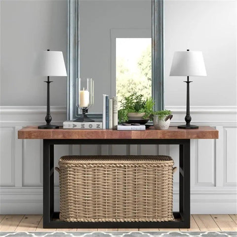Modern console table with wicker basket beneath, two blackened bronze table lamps on wooden top, white French drum shades.