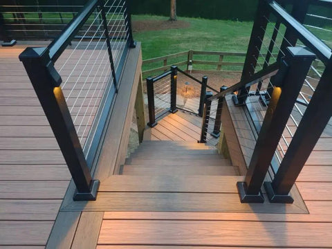 Low Voltage LED Wedge Deck Rail Light Kit 2W 2700K Warm Glow IP65 black die cast aluminum on stairs and railings at dusk.