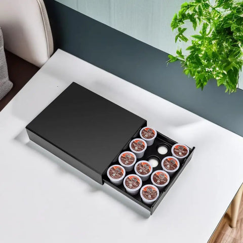 Black compact drawer for coffee pods, open with pods visible, fits 20; product is Stash Your Coffee With This Space Saving K Cup Pod Drawer Organizer For 20 Pods Fits Nespresso Dolce Gusto And K Cup Capsules Compact Black Storage Drawer That Stacks On Top Of Your Brewer.