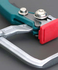 Close-up of heavy duty adjustable steel table clamps for woodworking workbenches with quick release ratchet and non slip buckle.
