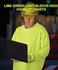 Person wearing high visibility long sleeve work shirt using laptop in outdoor night setting, lime green color, hard hat visible.