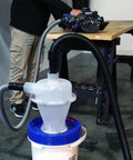 Assembled Quick Click Dust Collection Separator With Tough Five Gallon Locking Barrel And Ten Foot Commercial Hose providing suction at workshop.