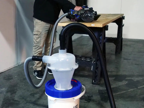 Assembled Quick Click Dust Collection Separator With Tough Five Gallon Locking Barrel And Ten Foot Commercial Hose providing suction at workshop.