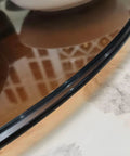 Close-up of Brown Round Tempered Glass Lazy Susan Turntable for Dining Table with 360 Degree rotation on marble surface