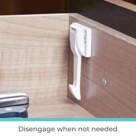 Drawer And Cabinet Tab Latches For Baby Proofing installed inside a drawer, showing white latch for kid-safe locking.