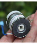 DC24V miniature electromagnetic clutch held by fingers; metal housing with a white plastic hub and blue wiring