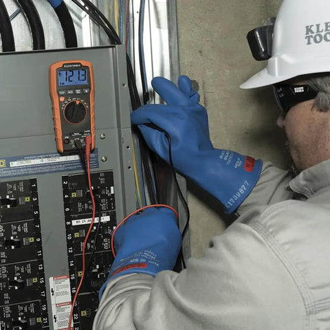Electrician using Auto Ranging TRMS Digital Multimeter MM420 Pro Grade With 600V AC DC Voltage 10A on circuit panel.