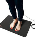 Person standing on Grounding Mat For Wellness 24x16 Inch Conductive Carbon Pad With 15 Foot Cord Non Slip Rubber Backing