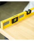 24 Inch Magnetic Top View Level Made In Usa featuring precision vials on a wooden surface, displaying ruler marks.