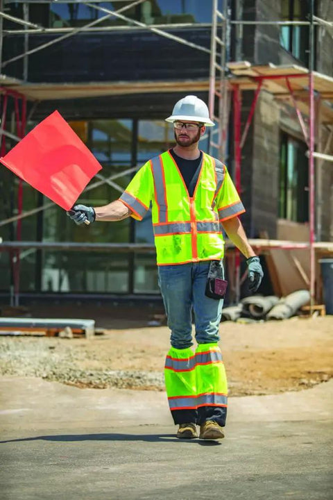 Mens Built Tough High Visibility Mesh Vest With Six Cargo Pockets And Secure Zipper Ansi Class Three worn by a construction worker holding a flag.