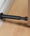 Heavy Duty 4.4 Inch Matte Black Door Stopper Set With Soft Rubber Tips, spring-loaded door bumper installed between door and wall.