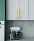 Modern kitchen with 10 Pack 5 Inch Brushed Gold Cabinet Handles For Kitchen Cabinets And Drawers installed on white cupboard doors.