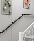 Heavy Hitter Black Wrought Iron Wall Mount Railing Bracket Kit Adjustable Support Post on staircase wall.