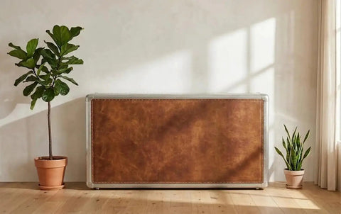 Knockout Aviator Sideboard Cabinet Drops That Aero Industrial Heat With Wraparound Weathered Brown Leather Riveted Silver Trim And Massive Storage Building A Solid 54 Inch Credenza Console Table For Any Cool Living Space, showcased beside potted plants.