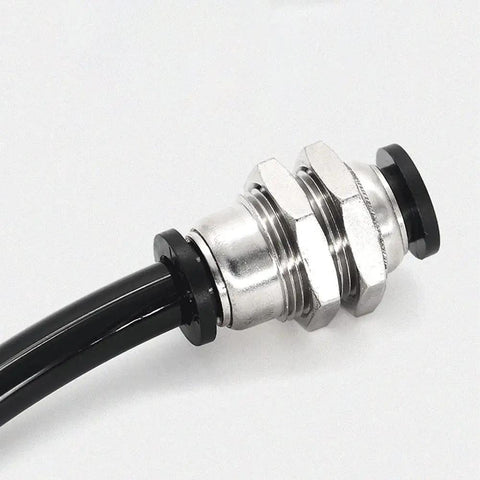 Close-up of a 10 Pack Bulkhead Union One Quarter Inch To One Quarter Inch Push To Connect Pneumatic Tube Fitting installed in line.
