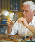 Man using 20X Watchmaker Loupe Magnifier for Pro Grade Precision, Portable Eye Loupe Glass Lens for Watches in a watch repair setting