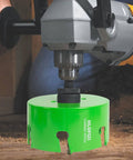 HLOFIZI 6-1/8-inch carbide-tipped hole saw on a drill, green multi-material cutter for recessed lights with arbor.