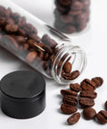 Keep Your Grind Fresh With This Premium Airtight Coffee Bean Storage Tube Set Featuring Four Smart Glass Jars And Clean Counter Display One Way Valve Seals In Aroma For Smooth Daily Brewing. Glass tube with coffee beans, black lid, resting on counter.