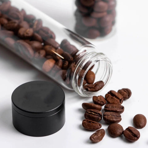 Keep Your Grind Fresh With This Premium Airtight Coffee Bean Storage Tube Set Featuring Four Smart Glass Jars And Clean Counter Display One Way Valve Seals In Aroma For Smooth Daily Brewing. Glass tube with coffee beans, black lid, resting on counter.