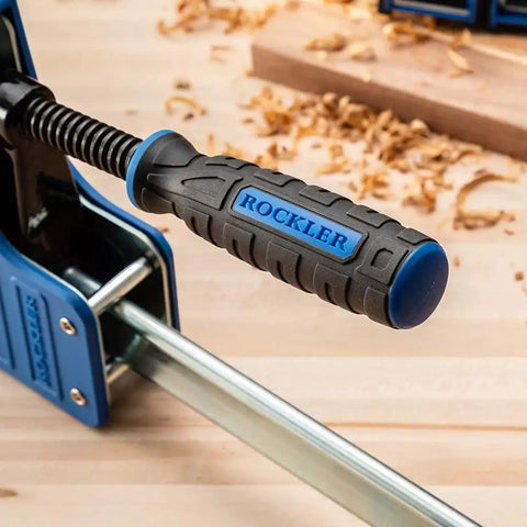Close-up of Beefy 24-Inch Parallel Bar Clamps For Woodworking with ergonomic handle on a wooden table