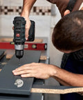 Person using drill to install 10Pcs Zinc Alloy Cabinet Shelf Pins with Flush Screws and Tarnish Resistant Finish on dark panel.