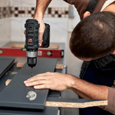 Person using drill to install 10Pcs Zinc Alloy Cabinet Shelf Pins with Flush Screws and Tarnish Resistant Finish on dark panel.