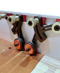 Close-up of Upgraded Router Table Saw Roller Feeder With One Way Bearings And Anodized Aluminum Body for steady wood feed control.