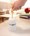 Two In One Battery And Electric Fully Automatic Pencil Sharpener For Regular Graphite And Drawing Pencils With Auto Feed And Auto Eject Adjustable Tip Size Includes AC Adapter Office And School Use White on wooden desk.