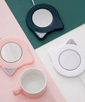 Keep Your Daily Grind Toasty With This Rapid Heating Desk Coffee Warmer Featuring Smart Temperature Controls and anti-slip base in pink, navy, and white.