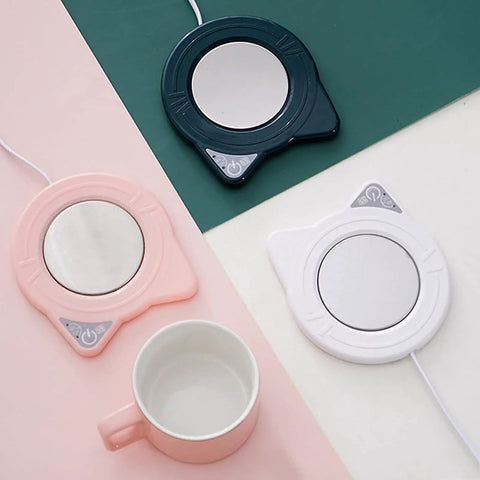 Keep Your Daily Grind Toasty With This Rapid Heating Desk Coffee Warmer Featuring Smart Temperature Controls and anti-slip base in pink, navy, and white.