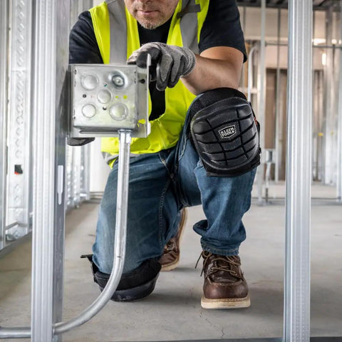 Worker wearing Lightweight Gel Knee Pads With Slip Resistant Caps And Adjustable Straps For Construction Work, kneeling on floor.