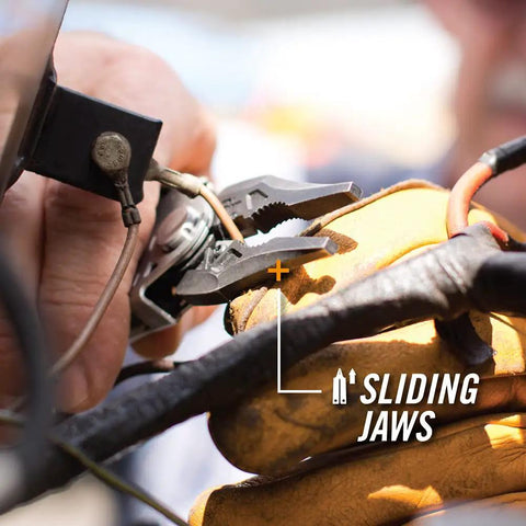 All-In-One Center-Drive Multitool Kit With 16-Piece Tool Set And 12-Piece Bit Set features sliding plier jaws in use with glove