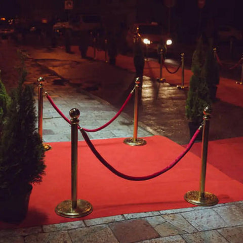 Two Piece Red Velvet Stanchion Rope Set With Polished Gold Hooks for VIP Crowds at night event with red carpet
