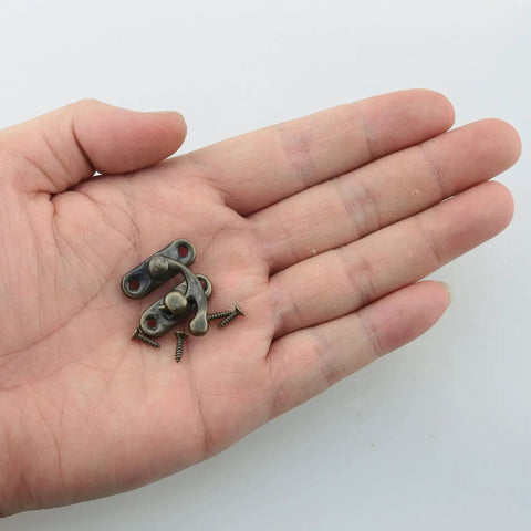 Hand holding Mini Swing Arm Clasp Latch Set Vintage Style Toggle Hasps For Suitcases And Jewelry Boxes, bronze with screws