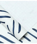 Close-up of Boho Peel And Stick Wallpaper Stripe Removable Navy And White Chevron Vinyl Contact Paper Mural with grid backing paper