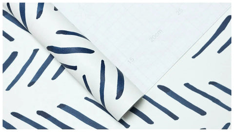 Close-up of Boho Peel And Stick Wallpaper Stripe Removable Navy And White Chevron Vinyl Contact Paper Mural with grid backing paper